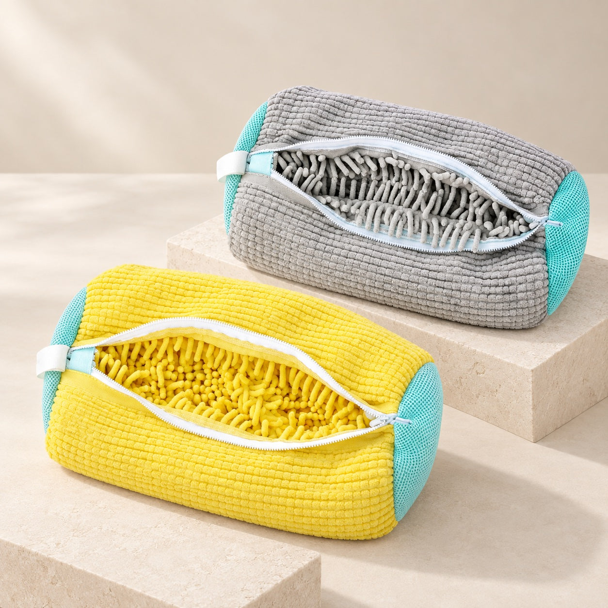 Yellow and gray ScrubKix shoe wash bags displayed open on stone platforms